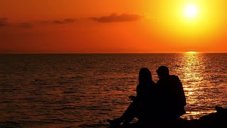 Couple Sitting On Seaside Stock Video