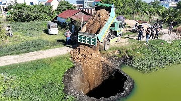 Starting a new project using a Komatsu D20p mini bulldozer, pouring soil into a deep pond