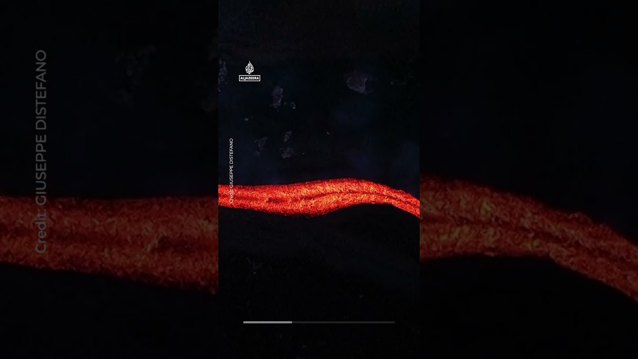 Orange lava flows stream from Mount Etna