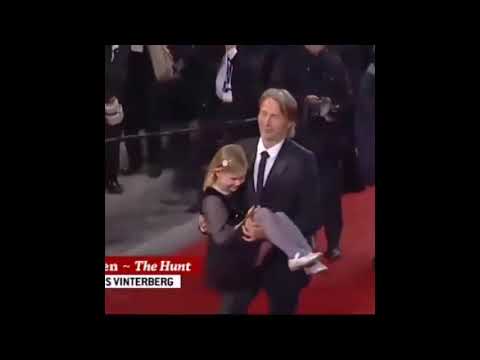 Mads Mikkelsen carrying his young co-star up the stairs at Cannes