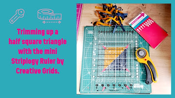 Trimming up half square triangles with the Creative Grids mini Stripology Ruler.