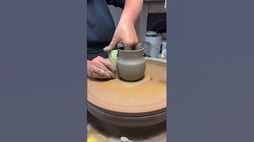 Throwing a curvy mug of the potters wheel with a profile rib I made.