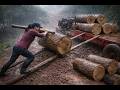 The girl loads heavy logs onto a truck in the forest, transporting them using an agricultural tracto