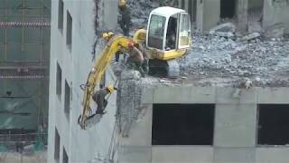 Beijing worker risks his life to demolish part of a building