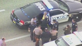 Naked woman kicks out window of police car
