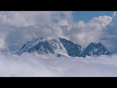 Amazing views of mountains and floating clouds. Timelapse 4K.
