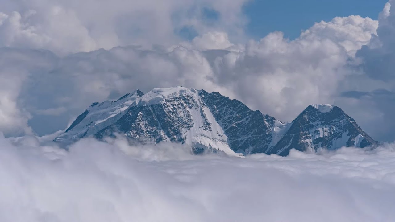 Amazing views of mountains and floating clouds. Timelapse 4K.