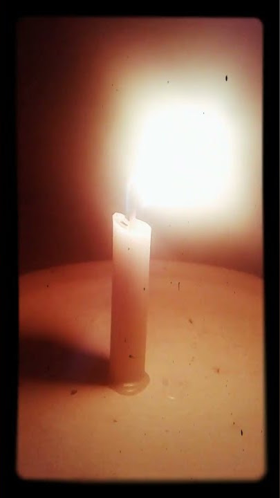 Lilin yang menyala dalam kegelapan malam diiringi hujan