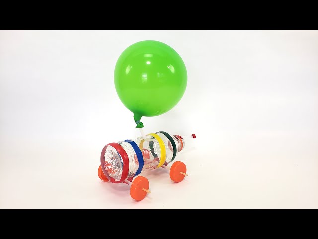 Boy blowing balloon from plastic car bottle at home stock photo