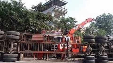 Container lao qua thành cầu rơi xuống suối, tài xế dính chặt trong cabin