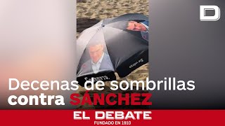 Decenas de sombrillas de Hazte Oír llamando corrupto a Pedro Sánchez decoran la playa de La Mareta