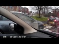 A lady driving with her dog on her knee and a baby in the back