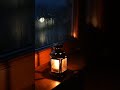 Small lantern glowing by a rainy window at night 🕯️