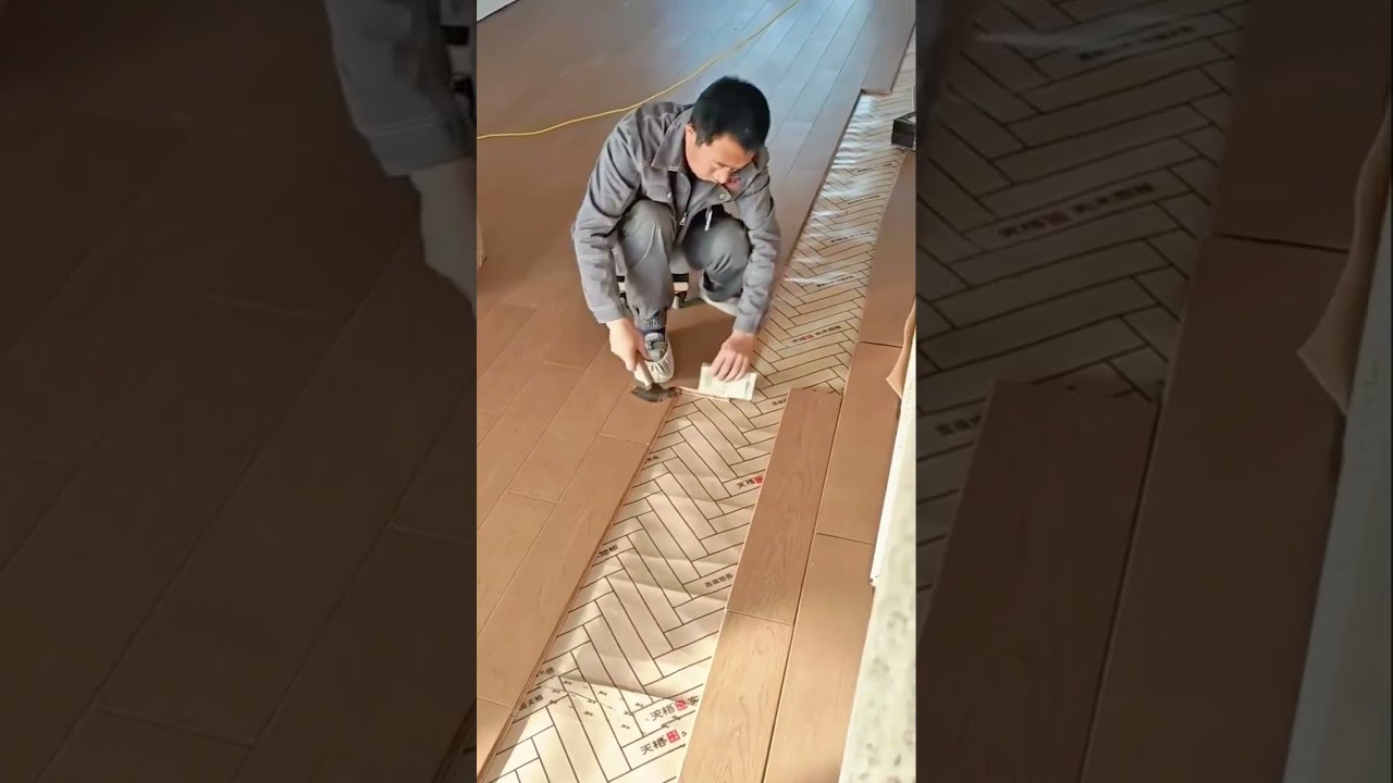 installing the light brown wood floors on the white pattern paper surface in the indoor room area