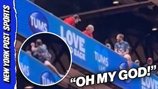 Cardinals fan DANGEROUSLY hangs off upper deck ledge then FIGHTS fans trying to save him!