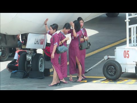 Pramugari Lion Air berteduh di Bawa Pesawat Menunggu Penumpang Turun di Bandara Ngurah Rai Bali