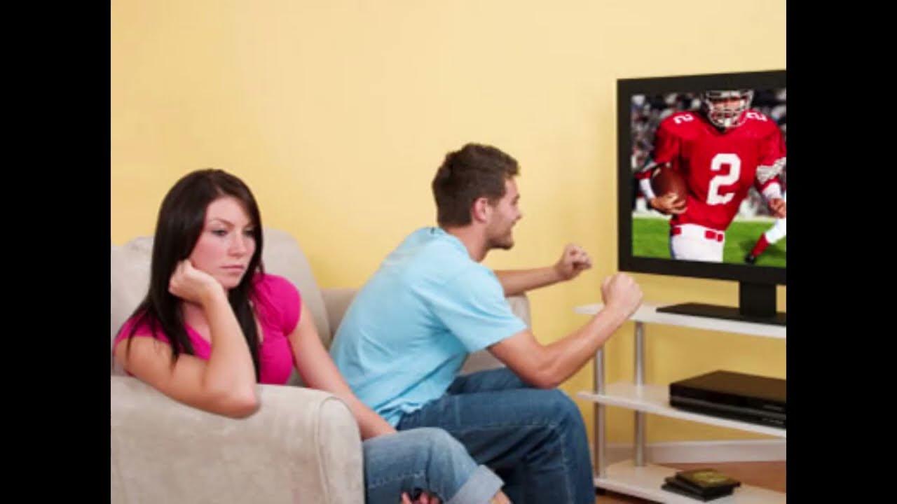 Пока муж смотрит телевизор жена. Парень с девушкой смотрят футбол. Мужчина и женщина смотрят футбол. Муж и жена смотрят футбол. Жена смотрит футбол.