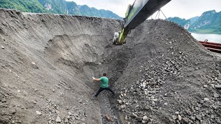 Barge unloading 4,900 tons of ore – Excavators and workers unloading together