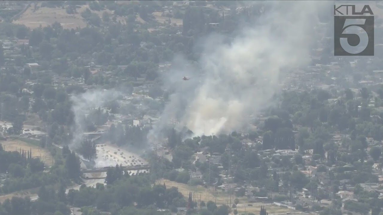 Firefighters battle brush fire near freeway in Granada Hills - YouTube
