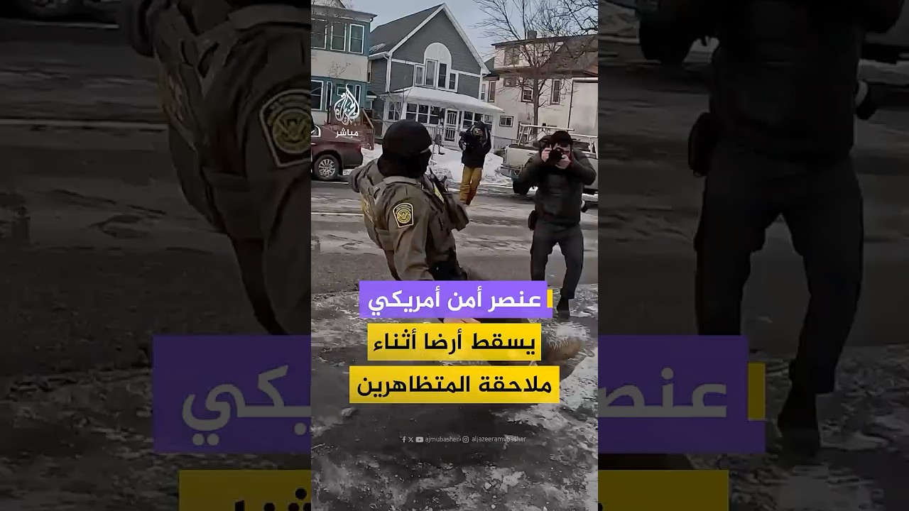 أحد عناصر وكالة الهجرة والجمارك الأمريكية يسقط أرضا بعد أن فقد توازنه خلال محاولة إمساك متظاهر