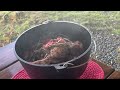 Leg of lamb in cast iron pot over camp fire