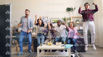 Slow motion of people hugging and laughing after successful sport game on TV