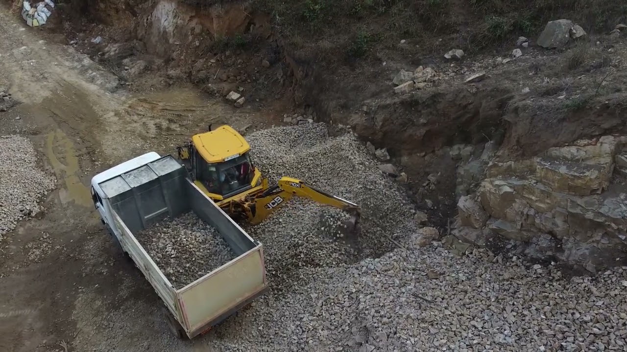 jcb 3dx super loading stone in a dump truck // drone shots