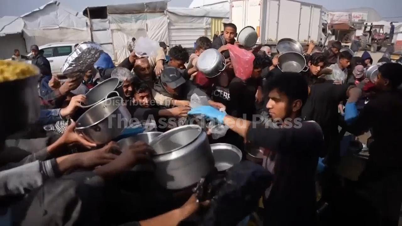 Gaza displaced line up at an Al-Muwasi field kitchen amid food shortages and spiking prices