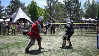 Medieval Knight breaks opponents helmet during full contact armored combat and knocks him down