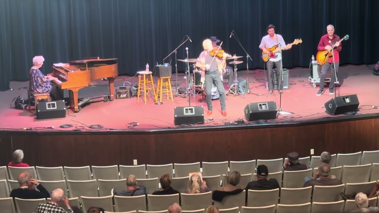 Fiddle player and band performing live on stage
