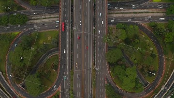Aerial ascending birds eye close up overhead top down view of multiple vehicles on a multi lane road
