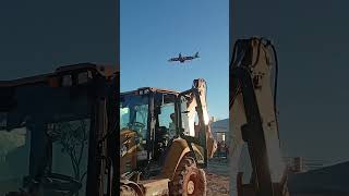 Retroescavadeira Caterpillar avião passando baixo