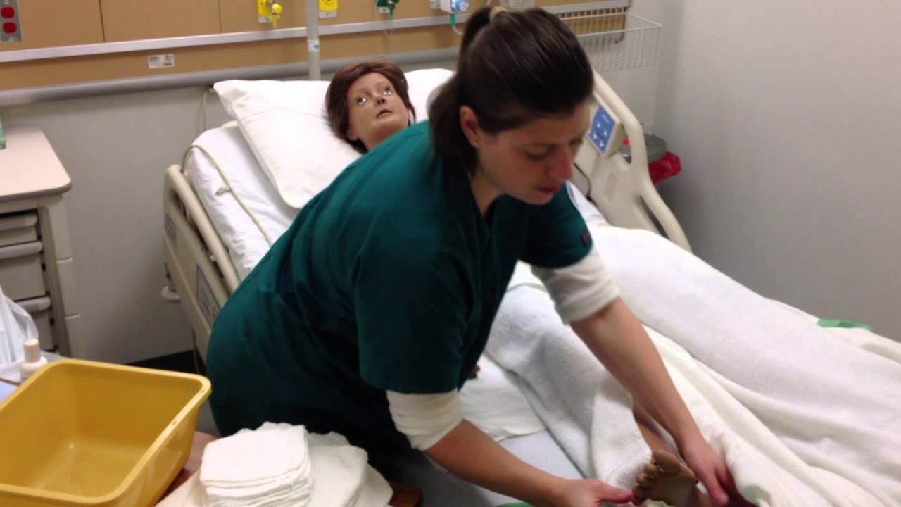 District nurse gives elderly patient a bed bath - Stock 