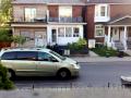 2 guys try to pick up a loonie dollar coin glued to sidewalk