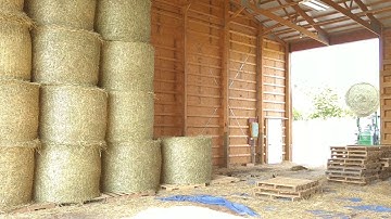 Stacking round bales in the hay barn