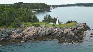 Relaxing Coastal Aerial Views with Lighthouse, Rugged Rocky Point & Fishing Boats In Harbour