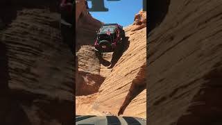 Four Wheeled Vehicle Drives Up Canyon Wall