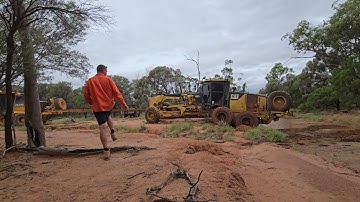 John Deere 770G pulling out the  CAT 160M Grader.