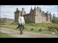 Scotsman Walking Wearing Kilt By A Castle On Spring History Visit To A River In Scotland