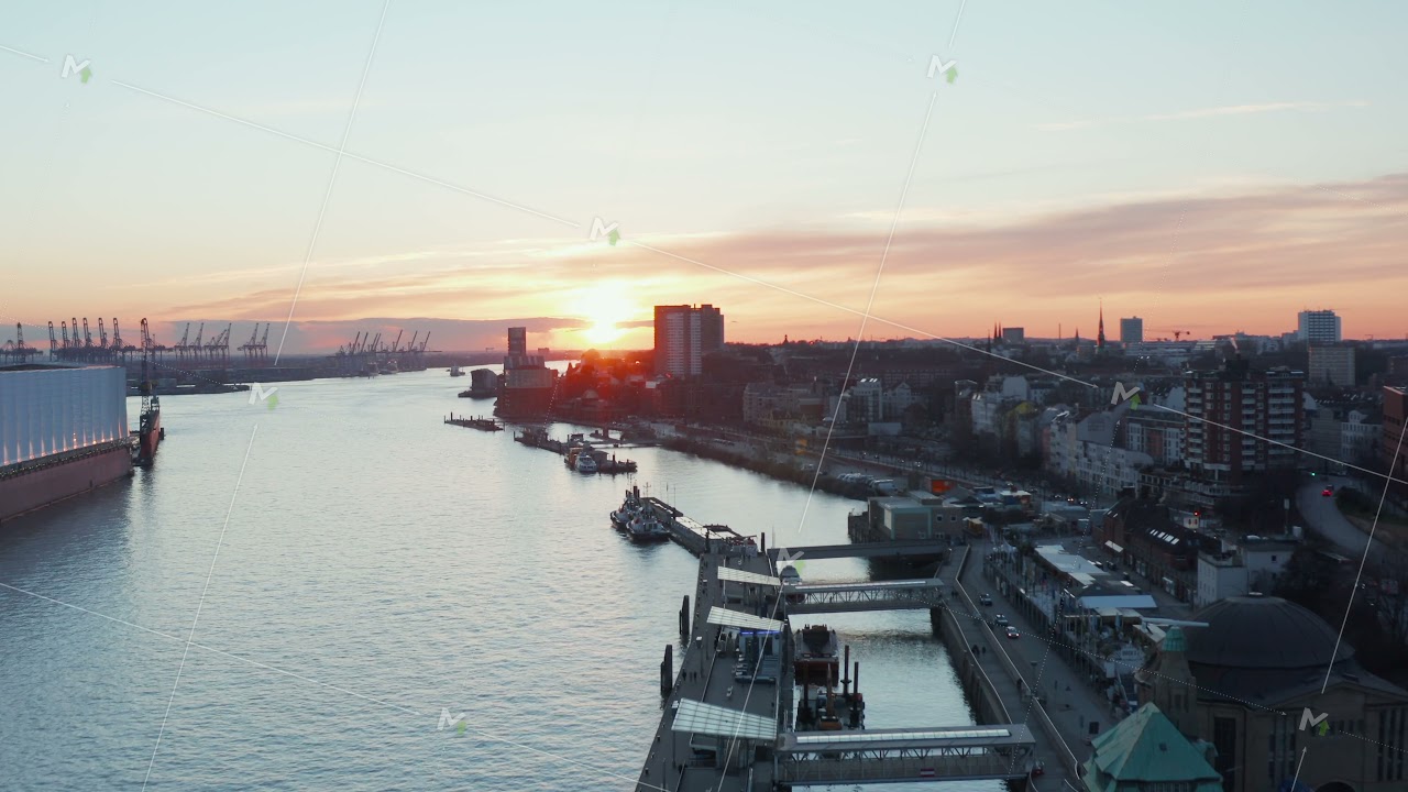 Ascending aerial view of Hamburg port in the sunset with calm river Elbe flowing through the city