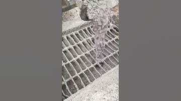 Pouring wet concrete onto reinforced steel grid for strong structural foundation