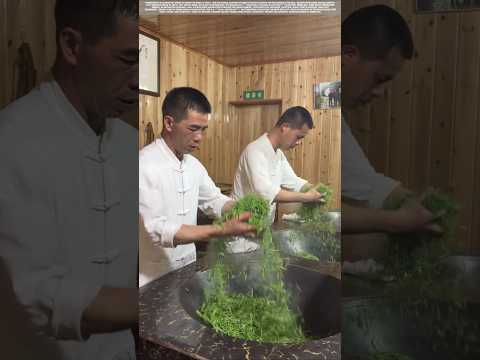 Stir-frying tea leaves by hand in a 200-degree iron wok.
