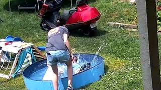 Little boy walks while Mom fills up above ground kiddie pools and falls inside (Security camera)