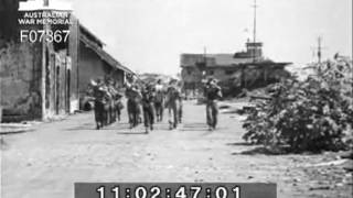 Liberation of English naval POW & occupation of Macassar
On 1 October 1945, troops of 2/14 Australian Infantry Battalion were transported from Balikpapan in HMAS Gascoyne and HMAS Burdekin to occupy Macassar. Prior to this, however, on 27 September 1945, troops of 2/27 Australian Infantry Battalion arrived at Macassar on HMAS Burdekin. 251858 (NX148) Brigadier Ivan Noel Dougherty taking the salute as troops march past. Liberation of English naval POW & occupation of Macassar