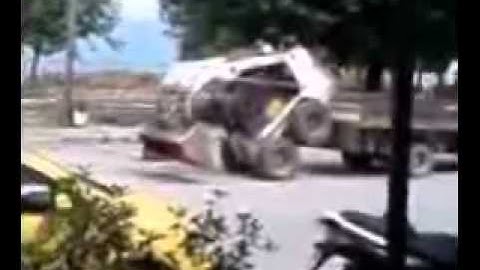 Bobcat being loaded on truck without ramp.wmv