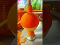 peeling a fresh orange fruit using a mechanical rotating tool to remove skin for food preparation