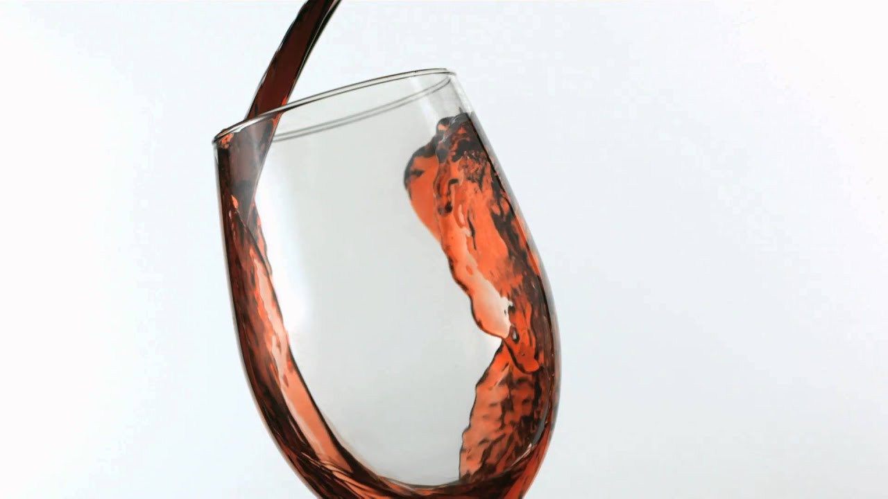 slow motion red wine poured into glass