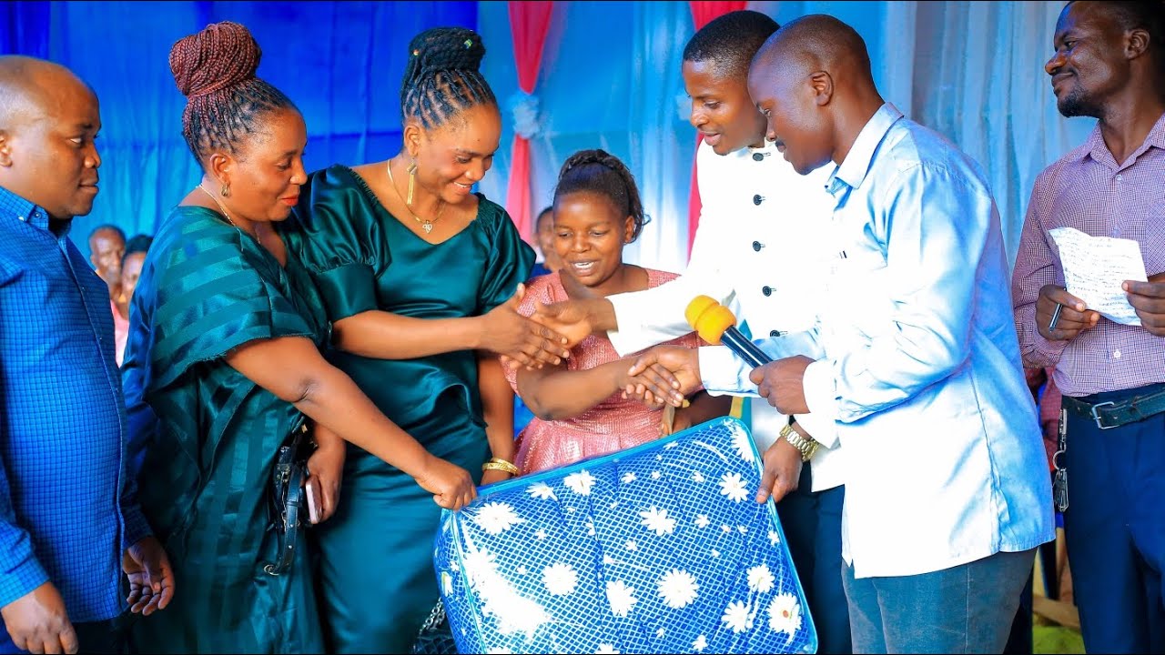 Familia ya MOc wakimkabidhi Mwl.Onesmo Mnkondya na familia yake zawadi kwenye harusi ya kijana wake.