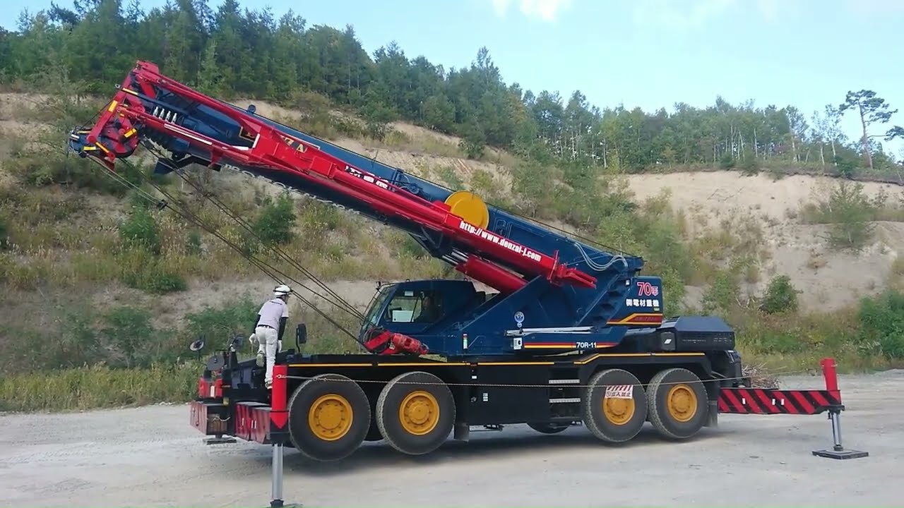 2台のラフテレーンクレーン比べてください トレーラーからコンクリートの塊おろす