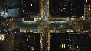 Cars weaving through a lively Manhattan, New York City intersection at night, highlighting vibrant News